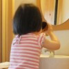 子供が洗面所でうがいをする様子