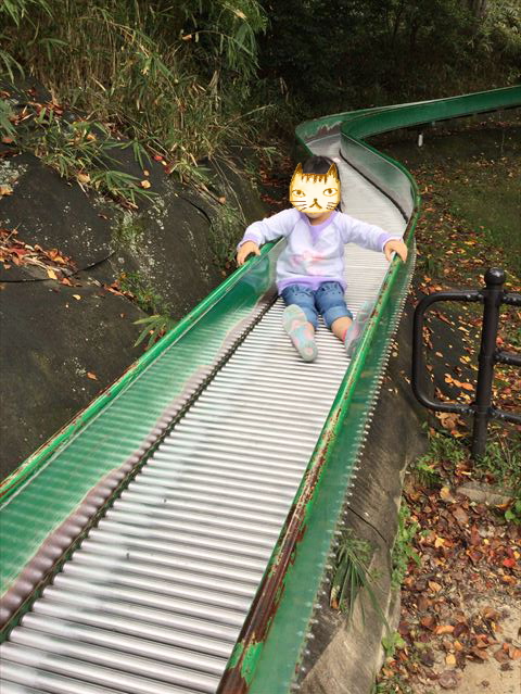 千里東町公園のロングスライダーを滑る子供