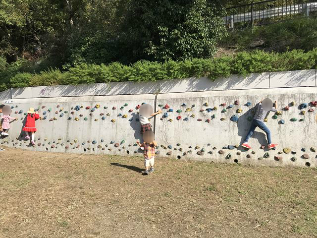 枚岡公園「みんなの広場」にあるクライミングウォールで遊ぶ複数の子供たち