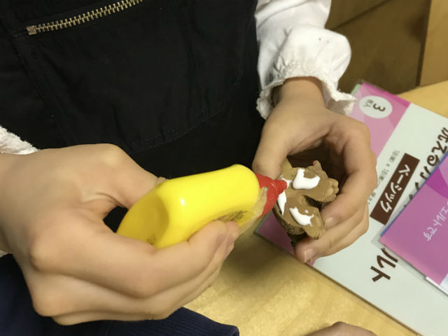 子供がスノードーム作り。オーナメントに接着剤をつけている